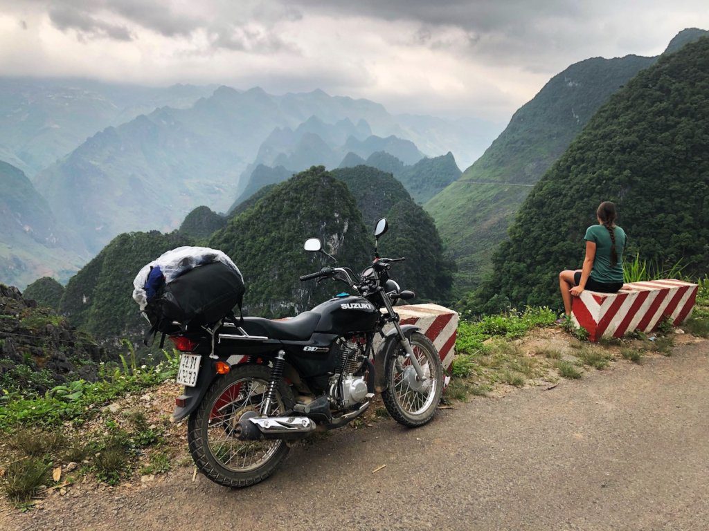 motorbike parked in front of a view of the ha giang loop