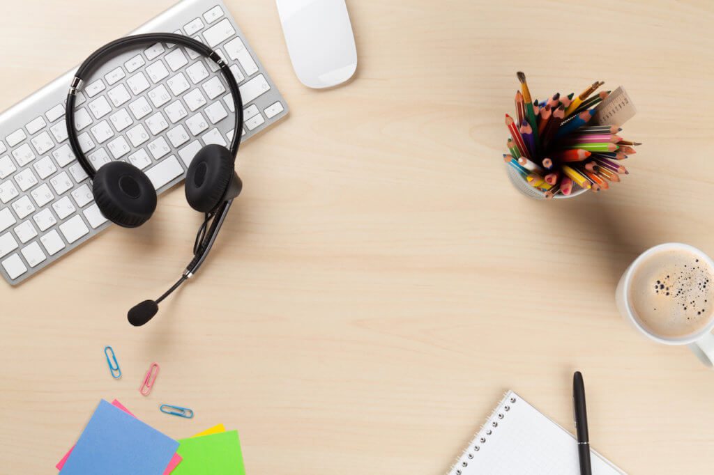 headset on a desk with keyboard and colored pencils, best online english teaching jobs for non-native speakers