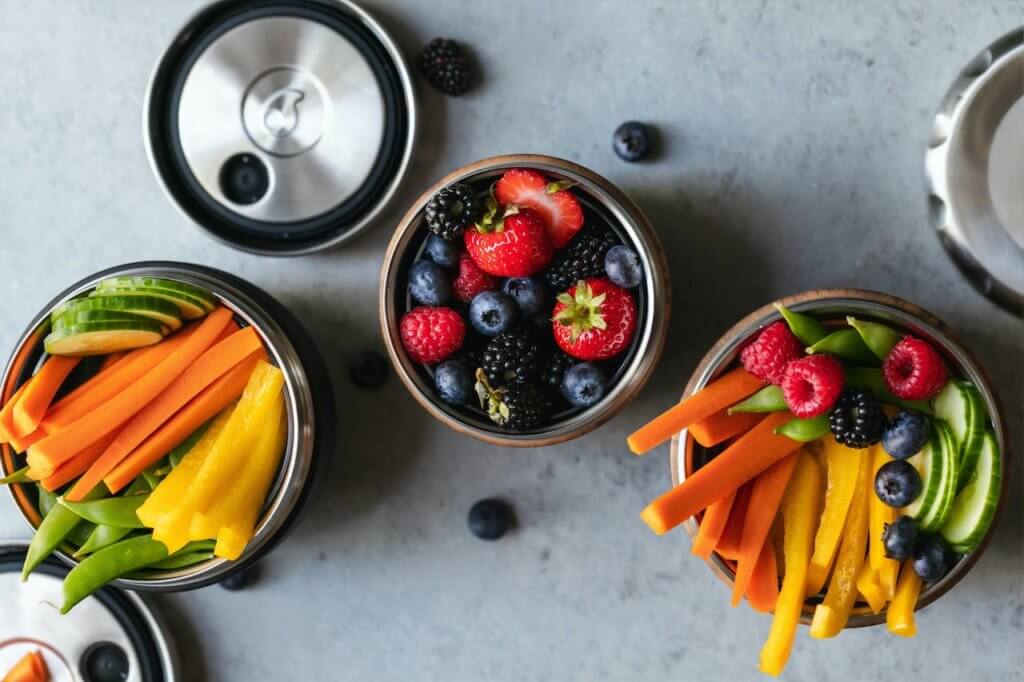 Three bowls of berries, cucumbers, sliced carrots and peppers make great healthy teacher snacks