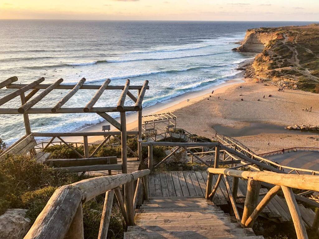 Wooden staircase leading down to the beach in Ericeira at sunset