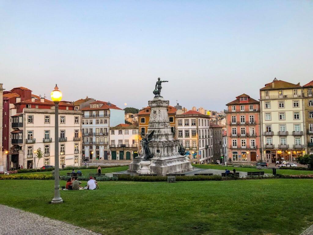 Pink, blue, and beige buildings in a town square in Porto