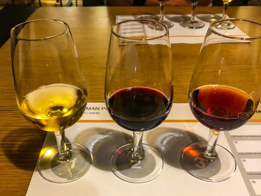 Three glasses of port wine (white, ruby, and tawny) at the Sandeman wine caves
