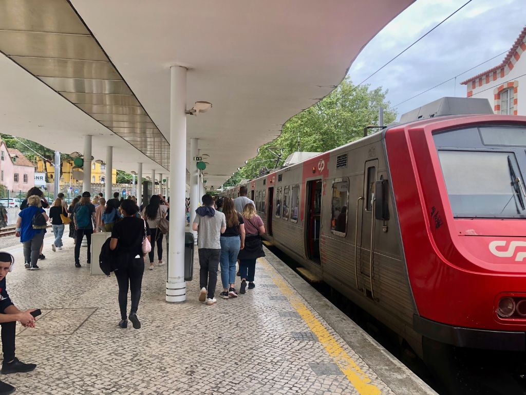 The Sintra train station with a red train at the platform and people walking toward the exit