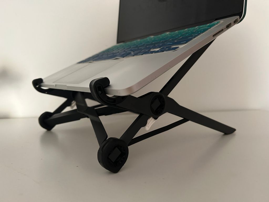 A black roost laptop stand with a laptop mounted on it at a slight elevation