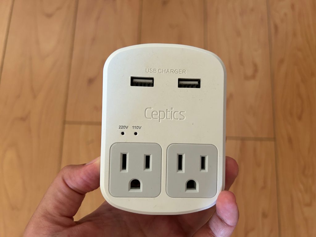 A universal travel adapter plug with two regular USA outlets and two USB outlets