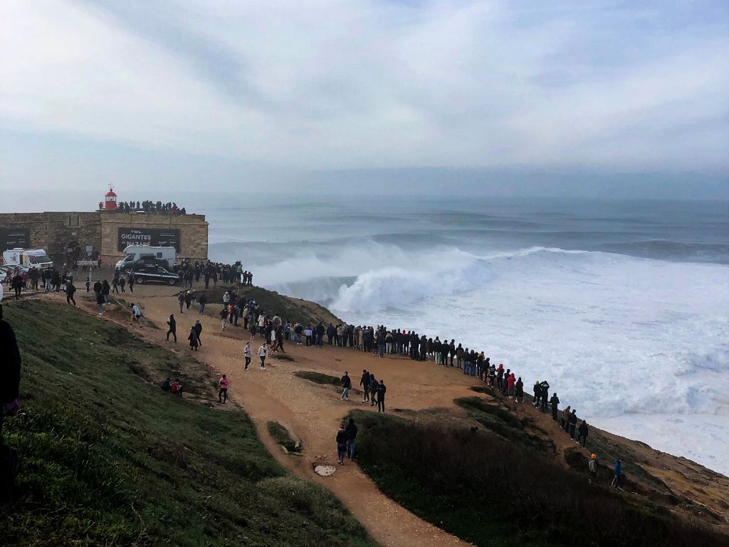 A crowd gathers on the cliff at Nazare to watch the big wave